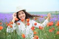 Young girl is in the lavender field with red poppy flowers, beautiful summer landscape Royalty Free Stock Photo