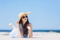 Young girl laying on the beach in a hat and sunglasses Royalty Free Stock Photo