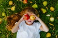 Young girl laying on green grass among pears, apples and small orange leaves Royalty Free Stock Photo
