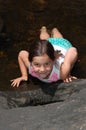 A young girl laying on her stomach in a country brook Royalty Free Stock Photo