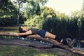 Young girl laying on a log in a park Summer time Royalty Free Stock Photo