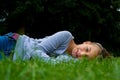 Young girl lays aside in grass smiling