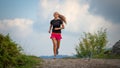 Young girl with lean physique running on hill dirt