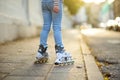 Young girl learning to roller skate on beautiful summer day on a street Royalty Free Stock Photo