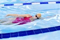 A young girl learns to swim during lessons in the pool. Individual training in the pool