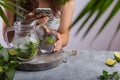 A young girl sits at a table with lemonade in her hand and looks into the phone