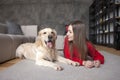 Young girl lies on the floor with golden retriever dog and smiles, a woman with a pet rest at home Royalty Free Stock Photo