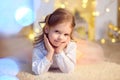 Young girl lies near a Christmas tree Royalty Free Stock Photo