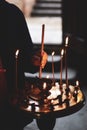 A young girl lighting a candle in a church in the name of the health of loved ones, the front and background are blurred with a Royalty Free Stock Photo