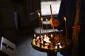 A young girl lighting a candle in a church in the name of the health of loved ones, the front and background are blurred with a Royalty Free Stock Photo