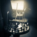 A young girl lighting a candle in a church in the name of the health of loved ones, the front and background are blurred with a Royalty Free Stock Photo