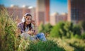 Young girl listening to music on headphones, urban street style, outdoor street style hipster dj woman in black cap and