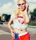 Young girl listening music in headphones, urban street style, outdoor street style hipster woman in sunglasses and dj headphones a Royalty Free Stock Photo