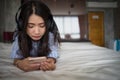 Young girl listening music from smartphone on bed at home. Asian woman lying on bed holding mobile phone listening music. Royalty Free Stock Photo