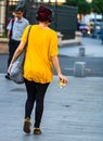 Young girl listening music while walking with a coffee cup in her hand in Bucharest, Romania, 2019