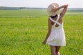 Young girl with long dark hair standing on a green field Royalty Free Stock Photo