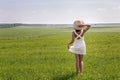 Young girl with long dark hair standing on a green field Royalty Free Stock Photo