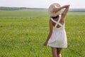 Young girl with long dark hair standing on a green field Royalty Free Stock Photo