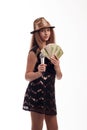 Young girl with long hair wearing a black dress and gold hat with a microphone in his hand and money on a white background in stud Royalty Free Stock Photo