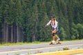 Young girl longboarding downhill on hillside road