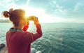 Young Girl Looking Through Binoculars At The Sea On A Bright Sunny Day, Rear View. Wanderlust Travel Journey Concept Royalty Free Stock Photo