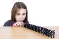 Young Girl Looking At Black Dominoes Lined Up On Wooden Board Isolated On White Royalty Free Stock Photo