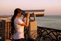 Young girl looking through a coin operated binoculars on the sea shore of Cannes, France. Royalty Free Stock Photo