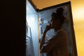 Young girl looking in fridge at night.