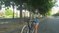 Young girl looking at her cell phone and holding a bicycle