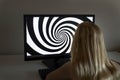 Young girl is looking at hypnosis spiral on her computer.