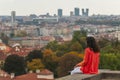 Young girl looking at the Old Town in European city Prague from observation deck