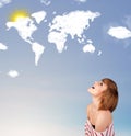 Young girl looking at world clouds and sun on blue sky Royalty Free Stock Photo