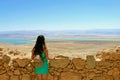 Young girl looks at the Dead Sea. Ruins of Herods Castle in Masada Fortress in Israel