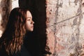 A young girl looks out of an old window in an ancient fortress Royalty Free Stock Photo