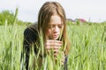 A young girl looks at a spikelet in a sown field Royalty Free Stock Photo