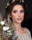 Young girl in a luxurious wedding dress. Portrait of the bride with a bouquet.