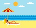 Young girl lying on the beach under an umbrella. Girl sunbathing on a deckchair on the beach