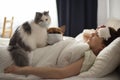 A young girl is lying in bed with heat, her French bulldog and a fluffy cat helps her. Coronovirus patient Royalty Free Stock Photo