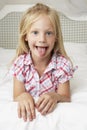 Young Girl Lying On Bed Pulling Funny Face