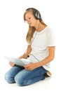 Young girl lying on the floor listening to music over white back Royalty Free Stock Photo