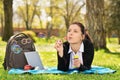 Young girl lying on a meadow blowing soap bubbles Royalty Free Stock Photo