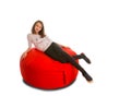 Young girl lying on round shape red beanbag chair Royalty Free Stock Photo