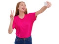 A young girl makes selfie and sticking out her tongue and showing two fingers. Isolated. Royalty Free Stock Photo