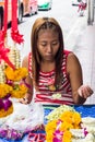 Young girl making flower garlands