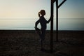 Young girl making yoga exercises at the sea beach Royalty Free Stock Photo