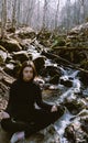 Beautiful girl making Yoga Pose lotus Sitting in a rock on a river Meditating in the forest with sunlight Royalty Free Stock Photo