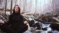 young girl making Yoga Pose lotus Sitting in a rock on a river Meditating in the forest with sunlight Royalty Free Stock Photo