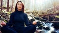 young girl making Yoga Pose lotus Sitting in a rock on a river Meditating in the forest with sunlight Royalty Free Stock Photo