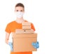 Young girl in a mask and an orange t-shirt holds cardboard boxes for delivery isolated on white background. Donation box Royalty Free Stock Photo