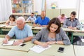 Young girl and mature man take a written exam